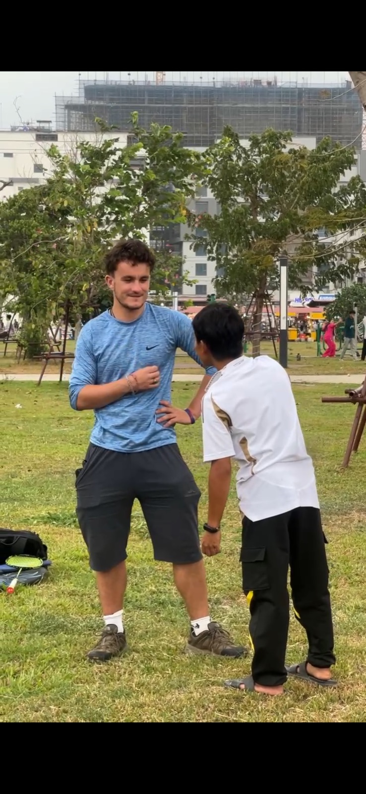 Ollie talking with someone outdoors during his Cambodia community visit