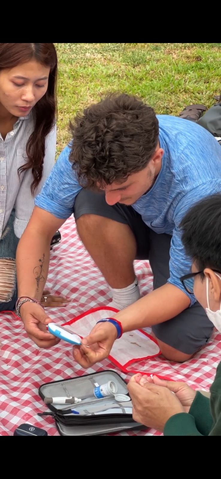 Ollie taking part in a glucose-monitoring activity during his Cambodia community visit